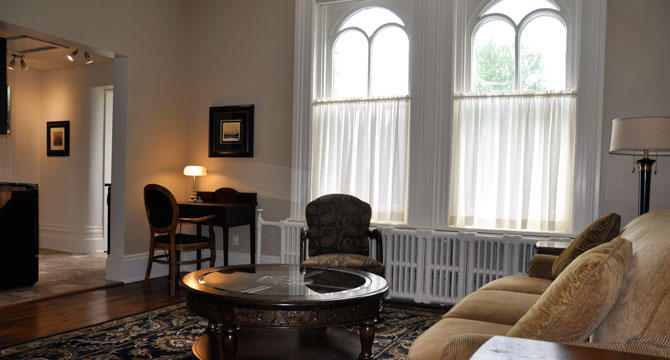 Apartment living room with tall arched windows and hardwood flooring