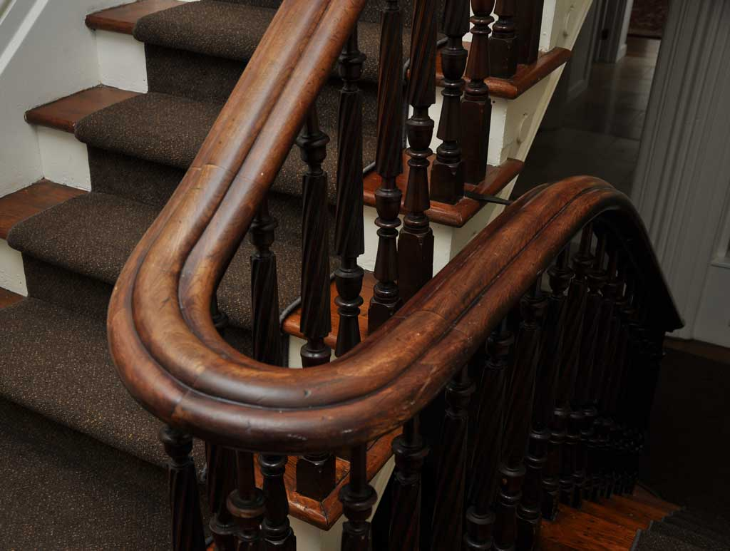 Curved wooden handrail and original staircase at King West Apartments